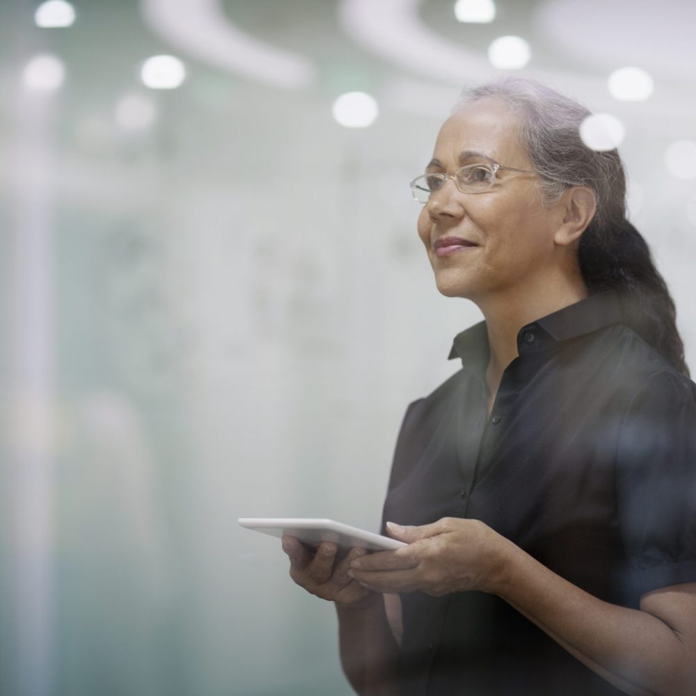 Senior woman with smart tablet computer in office